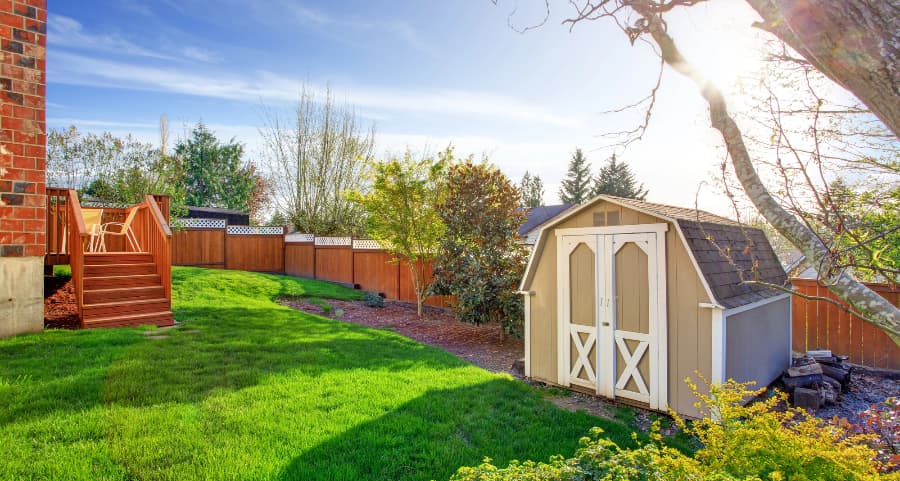 Fenced backyard with storage shed in Huntington